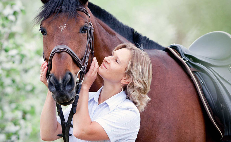 Woman holding brown horse